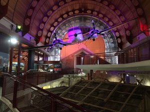 Plane hanging from the roof of museum with purple lighting